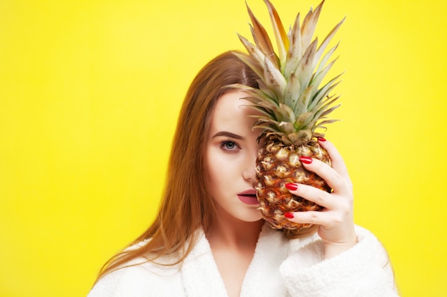 Jeune Femme Tenant Un Ananas Mûr Près De Son Visage.