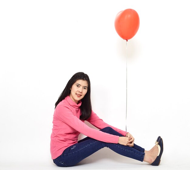 Jeune femme tenant un ballon rouge