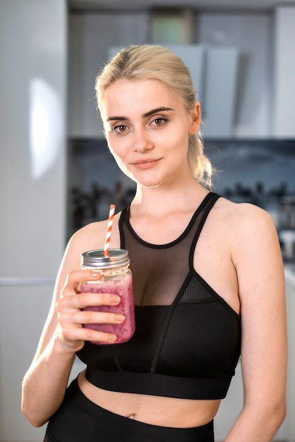 Jeune femme tenant une boisson smoothie saine