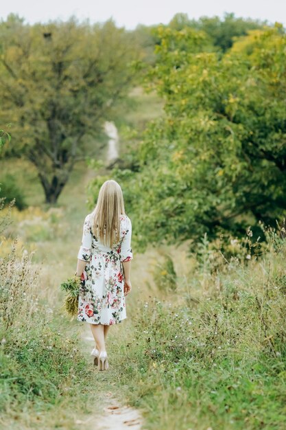 Jeune femme tenant un bouquet de fleurs sauvages