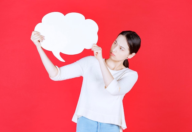 Jeune femme tenant une bulle de dialogue avec une forme de nuage