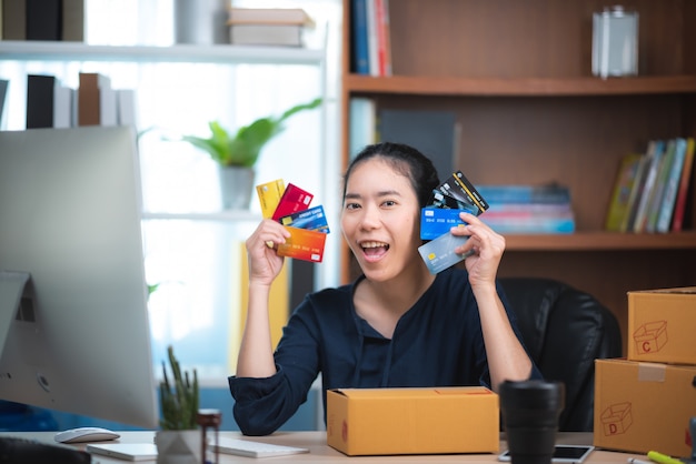 Jeune femme tenant une carte de crédit et à l'aide d'un ordinateur portable. Concept d'achat en ligne