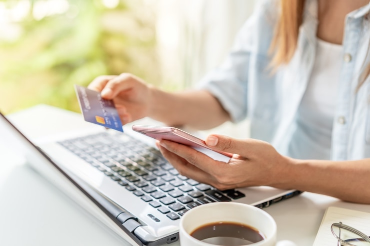 Photo jeune femme tenant une carte de crédit et à l'aide de smartphone pour effectuer des achats de paiement en ligne