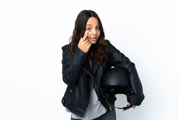 Jeune femme tenant un casque de moto sur fond blanc isolé montrant quelque chose