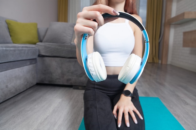 Jeune femme tenant un casque sans fil.