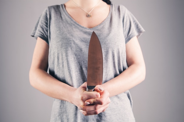 Jeune femme tenant un couteau devant elle