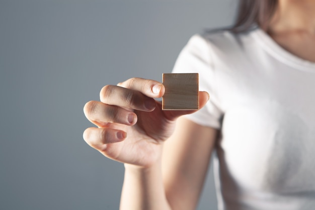 Jeune femme tenant un cube en bois