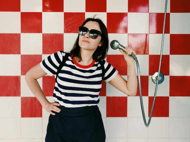 Photo une jeune femme tenant une douche à main