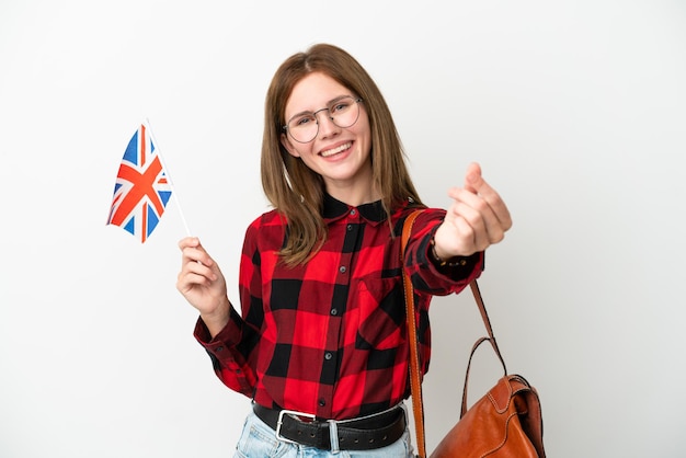 Jeune femme tenant un drapeau du Royaume-Uni isolé sur fond bleu faisant un geste d'argent