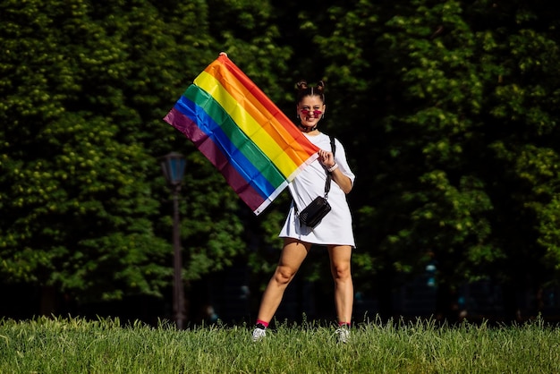 Jeune femme tenant un drapeau de fierté LGBT dans ses mains