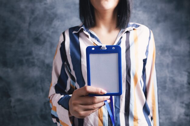 Jeune femme tenant une étiquette d'identification