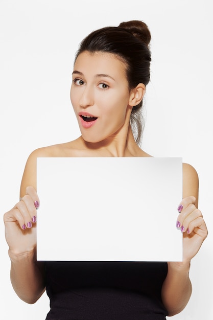 Jeune femme tenant une feuille de papier vierge