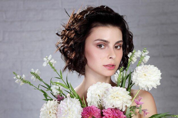 Jeune femme tenant des fleurs dans ses mains