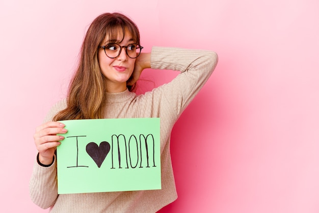 Jeune femme tenant un j'aime maman isolée toucher l'arrière de la tête, penser et faire un choix