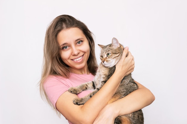 Une jeune femme tenant un jeune chat tigré adorable dans ses mains Amitié d'un animal de compagnie et de son propriétaire