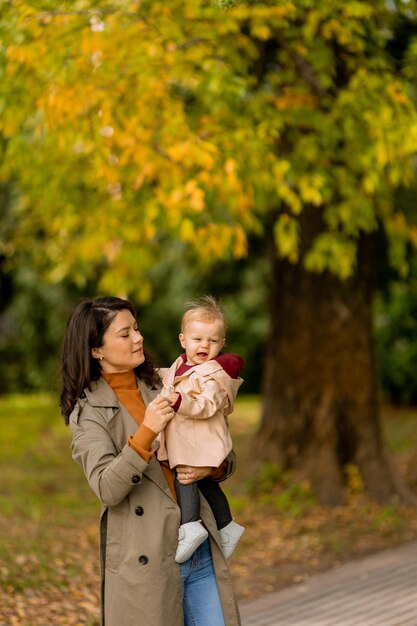 Une jeune femme tenant une jolie petite fille dans le parc d'automne