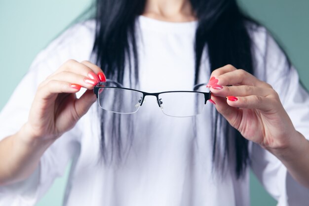 Jeune femme tenant des lunettes optiques