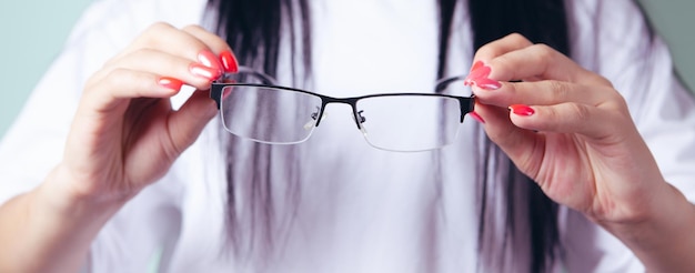 Jeune femme tenant des lunettes optiques