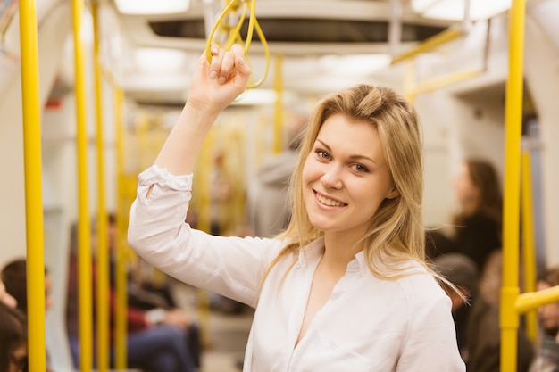 Jeune femme tenant avec la main droite à l&#39;intérieur du tube de Londres.