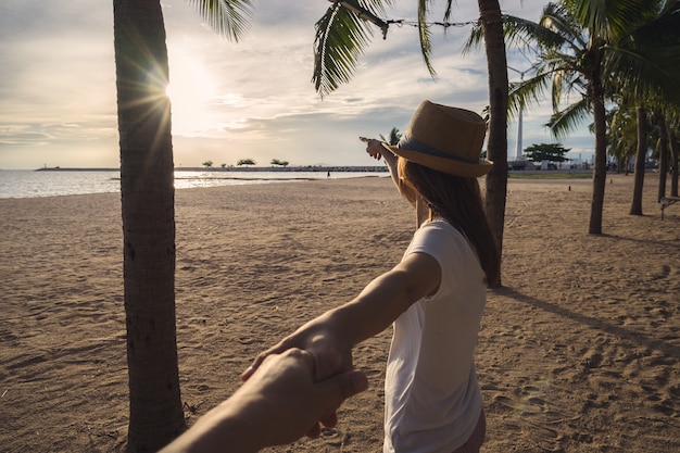 jeune femme tenant la main de l&#39;homme sur la plage