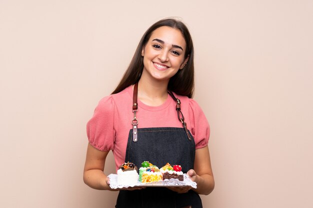 Jeune femme tenant des mini gâteaux