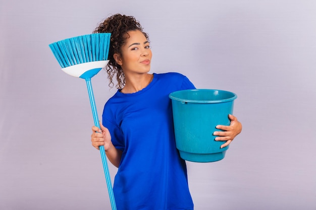 Jeune femme tenant des outils de nettoyage isolés sur blanc. Femme au foyer. Nettoyeur.