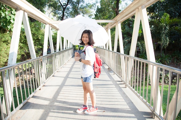Jeune femme tenant un parapluie blanc.