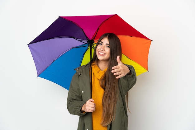 Jeune femme tenant un parapluie isolé sur fond blanc se serrant la main pour conclure une bonne affaire