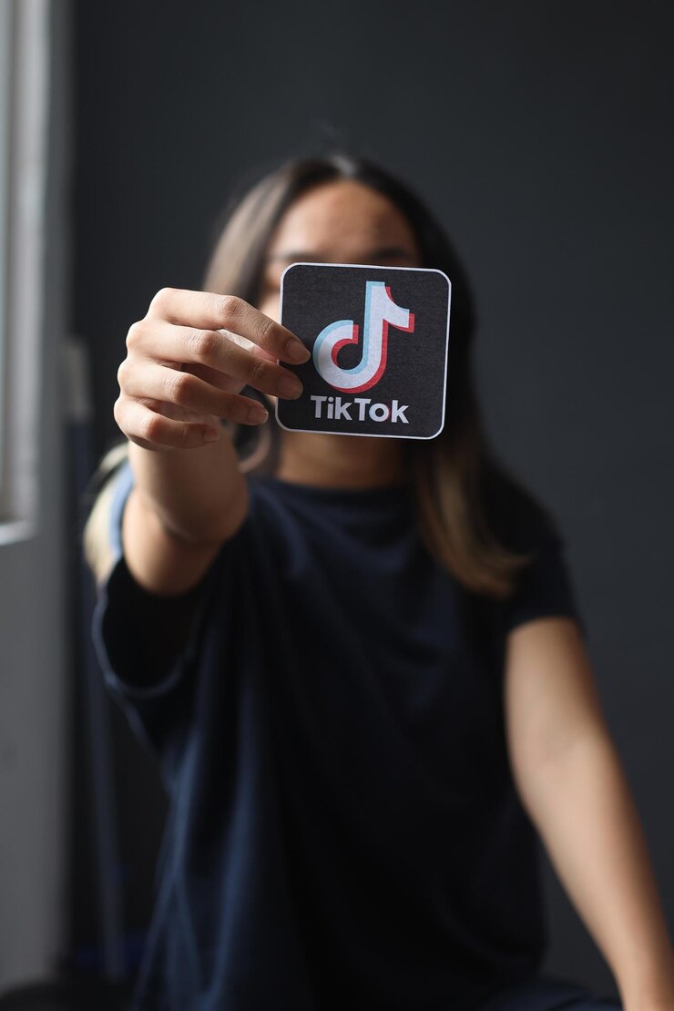 Jeune femme tenant la photo du logo Tiktok à la main. Concept de jeunesse, technologie, social et réseautage