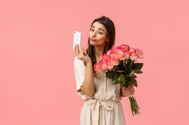 Une jeune femme tenant une rose rose sur un fond gris