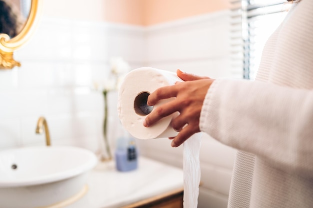 Jeune femme tenant un rouleau de papier toilette