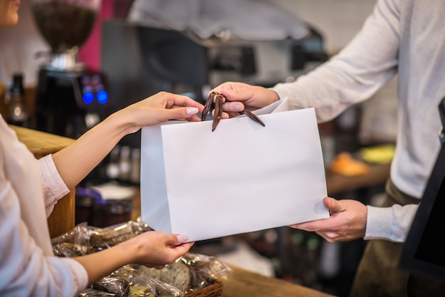 Jeune femme tenant un sac d'une boulangerie