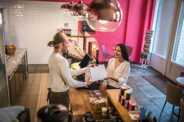 Jeune femme tenant un sac d'une boulangerie