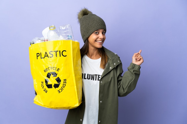 Jeune femme tenant un sac plein de plastique vers l'arrière