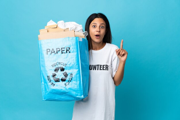 Jeune femme tenant un sac de recyclage plein de papier