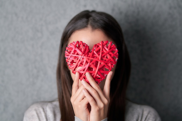 jeune femme, tenue, a, coeur valentine, décoration, devant, elle, visage