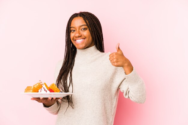 Jeune, femme, tenue, gaufre, Sourire, élévation, pouce, haut