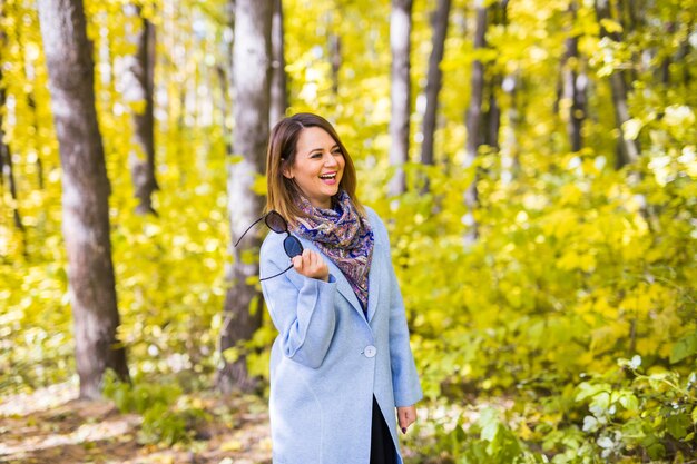 Jeune femme, tenue, lunettes soleil, à, les, automne, parc