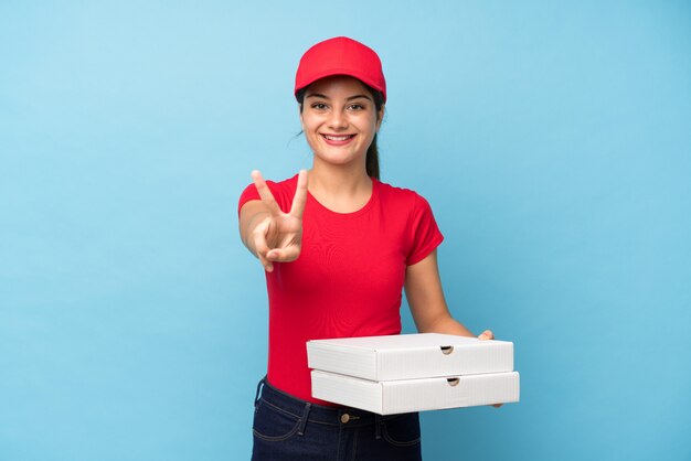 Jeune femme, tenue, pizza, mur rose isolé, sourire, projection, signe victoire