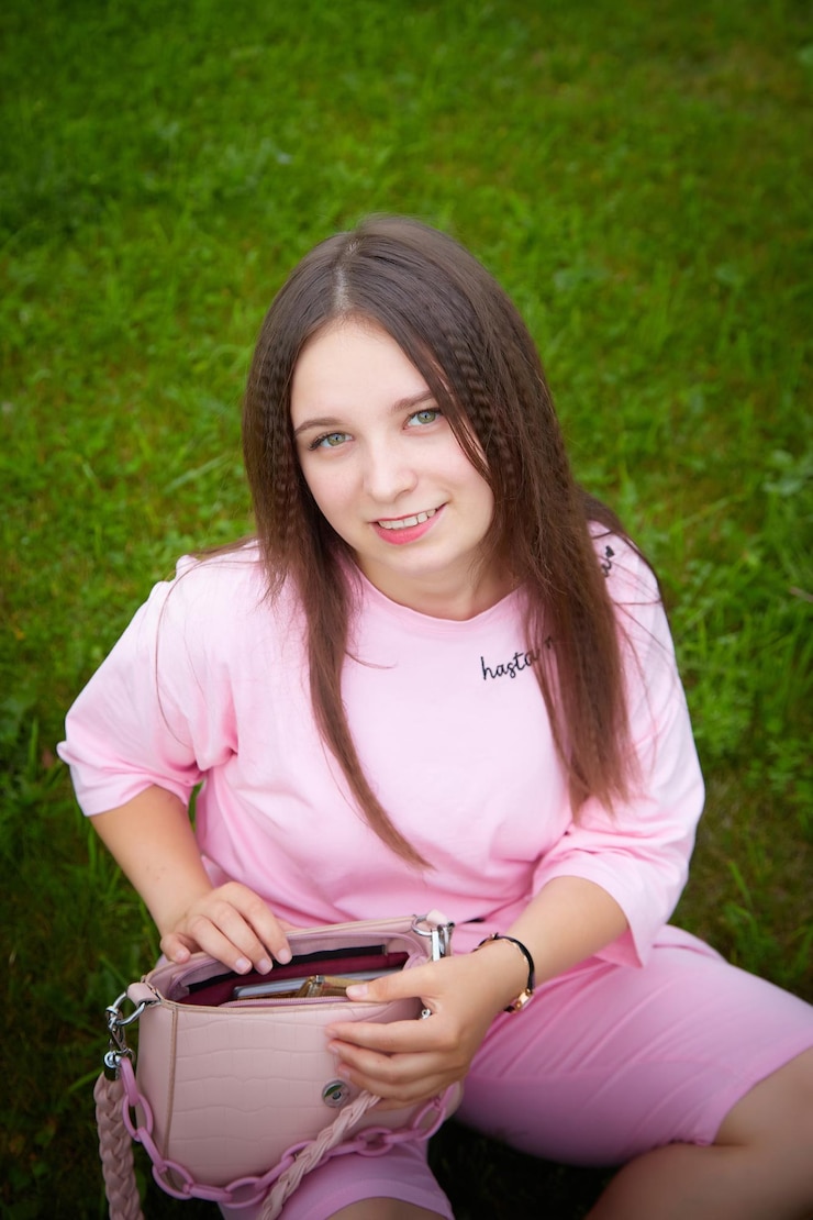 Photo une jeune femme en tenue rose se promène dans la ville tout en tenant un téléphone portable