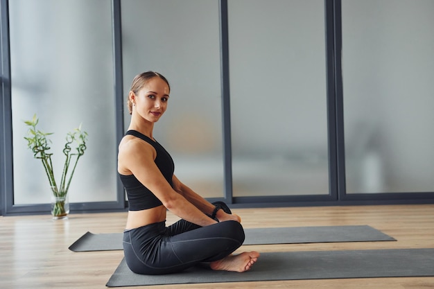 Jeune femme en tenue sportive et au corps mince a une journée de yoga fitness à l'intérieur