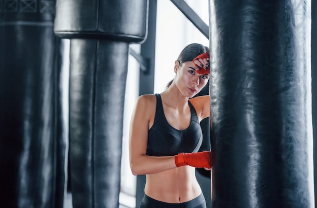 Une jeune femme en tenue sportive est dans la salle de gym en train de faire de l'exercice. Conception de la boxe.