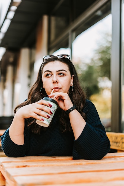 Jeune femme, sur, a, terrasse, café buvant