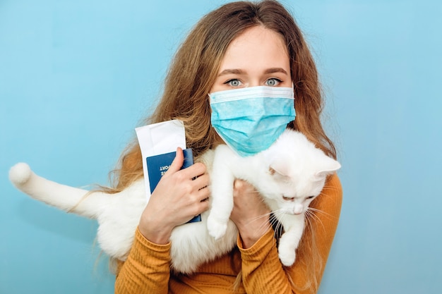 Une jeune femme tient un chat blanc dans ses bras.