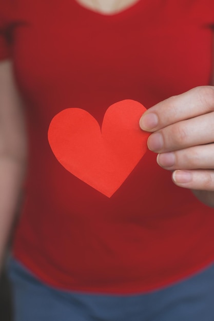 Jeune femme tient un coeur rouge découpé dans du papier Photo authentique Saint Valentin Fête des mères