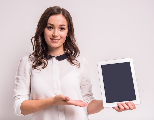 Jeune femme tient debout tablette numérique.