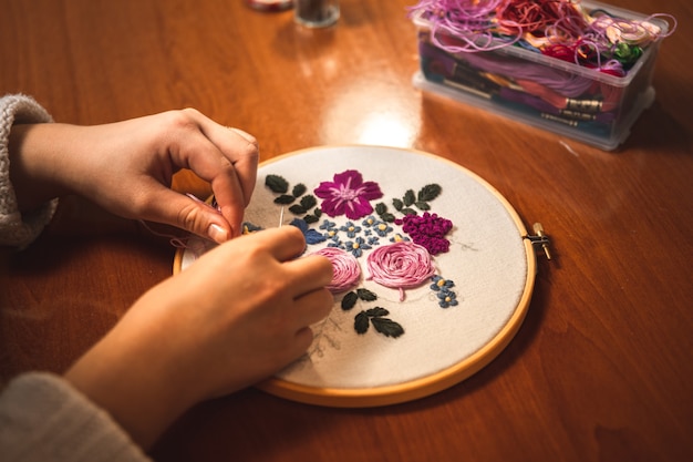 Jeune femme tissant une broderie