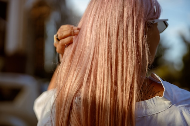 Jeune femme touchant ses cheveux dans la rue