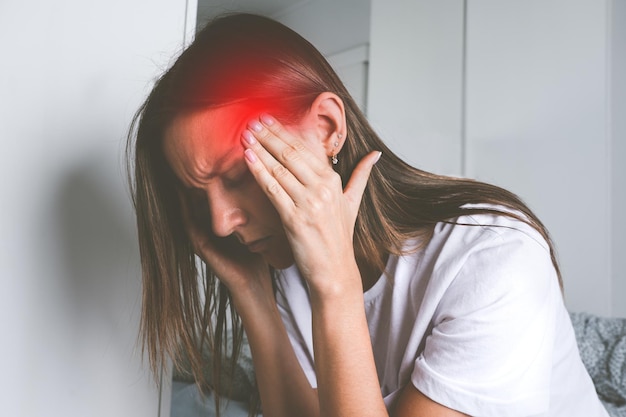 Jeune femme touchant ses tempes et souffrant de maux de tête ou de migraine