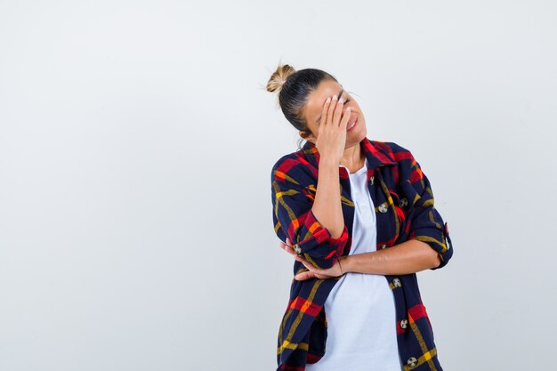 Jeune femme touchant la tête avec sa main en chemise à carreaux et à la nostalgie